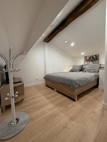 une chambre avec un lit et un parquet dans l'établissement La Demeure du Chevalier, à Saint-Cyr-lʼÉcole