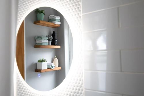 een badkamer met een ronde spiegel en handdoeken bij KingstonStays Spacious Historic Downtown Stableman's House Loft in Kingston