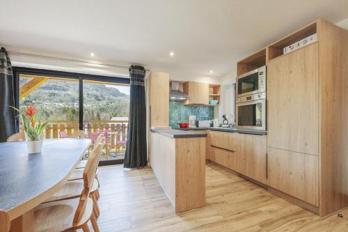 une cuisine avec une table et une grande fenêtre dans l'établissement Carline, à Morillon