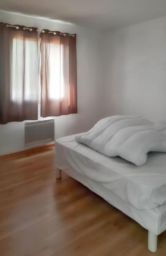 une chambre blanche avec un lit et une fenêtre dans l'établissement Maison chaleureuse à Sully avec vue sur la montagne, à Sully