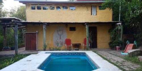 a house with a swimming pool in front of a house at La comarca Eco-casa in Río Ceballos