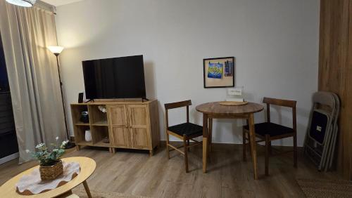 a living room with a television and a table and chairs at Apartamenty Paderewski II in Bielawa