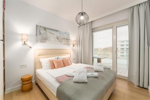 a bedroom with a bed with towels on it at POLANKI AQUA APARTAMENTY - Family Pool & Wellness in Kołobrzeg