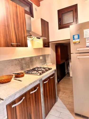 a kitchen with wooden cabinets and a stove top oven at Marsala al centro n 9 in Marsala