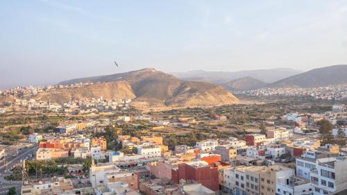 an aerial view of a city with buildings and mountains at Tayyurt host in Agadir