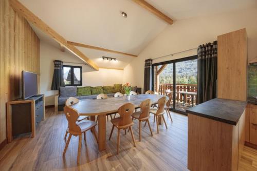 Il dispose d'une cuisine et d'un salon avec une table et des chaises en bois. dans l'établissement Oxalis, à Morillon