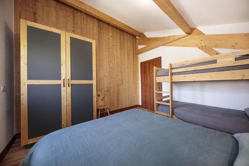 une chambre avec un lit et un lit superposé dans l'établissement Oxalis, à Morillon