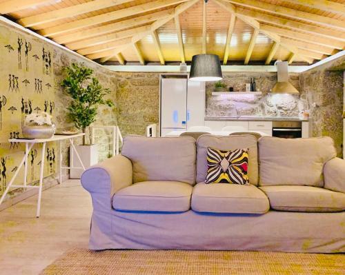 a living room with a couch and a kitchen at Pedacinho do Céu in Vieira do Minho