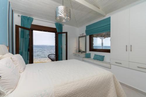 a bedroom with a bed and a view of the ocean at Villas Agapitos in Ayios Nikolaos Sithonia