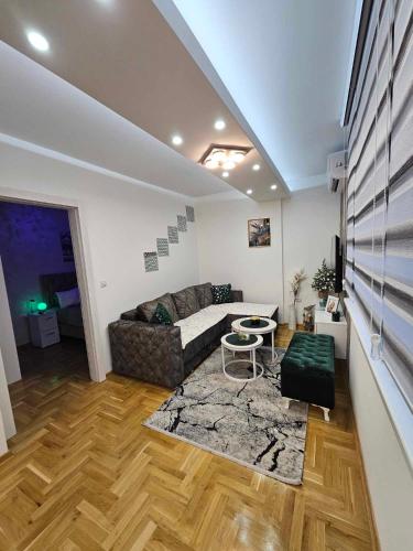 a living room with a couch and a table at Apartman Daluxst in Vrnjačka Banja