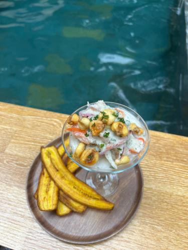 a plate with a bowl of food and some bananas at Rincon de la Sierra Minca in Minca