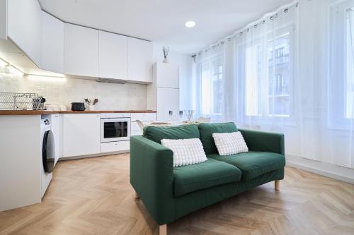 un salon avec un canapé vert et une cuisine dans l'établissement Le Talleyrand Hyper centre Place d'Erlon, à Reims