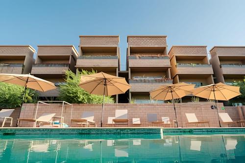 a hotel with chairs and umbrellas next to a swimming pool at Condominios Evamar San Carlos in San Carlos