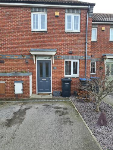 a red brick house with a blue door at Rays Lodge 2 in Middlesbrough