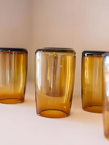 four yellow glasses sitting on a table at Condominios Evamar San Carlos in San Carlos