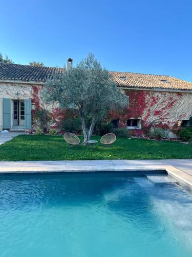 - une piscine avec 2 tables de ping-pong en face d'une maison dans l'établissement Le Mas des Poules chambres d'hôtes de charme, à Saint-Roman-de-Malegarde