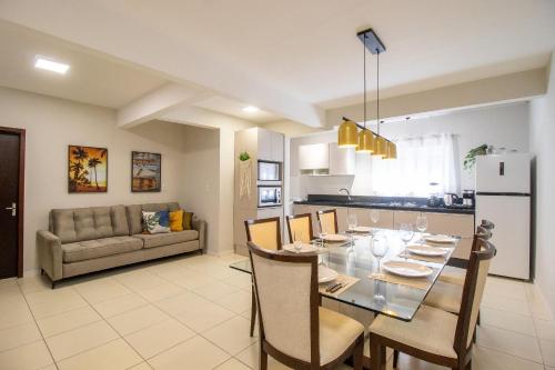 una sala da pranzo e una cucina con tavolo e sedie di JOA33 - 3 Dorm, Climatizado, Garagem a Balneário Camboriú