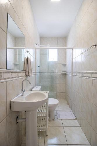 a white bathroom with a sink and a toilet at JOA33 - 3 Dorm, Climatizado, Garagem in Balneário Camboriú
