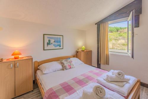 a small bedroom with a bed and a window at Zeljana in Metajna