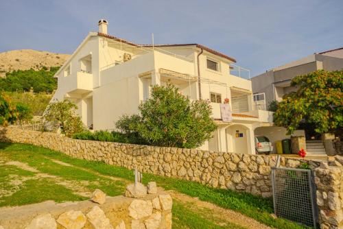 a house with a stone wall in front of it at Zeljana in Metajna