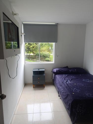a small bedroom with a bed and a window at apto san luis 407 in Armenia