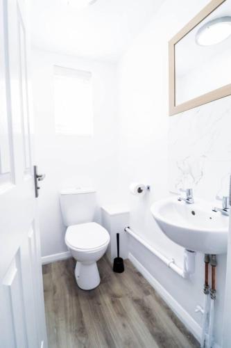 a white bathroom with a toilet and a sink at 3br Family Retreat With Free Parking Bexleyheath in Bexleyheath