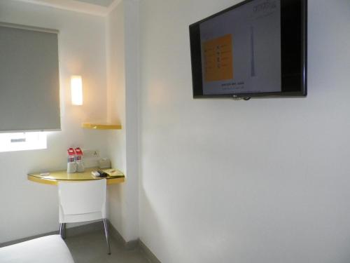 a room with a small table and a flat screen tv on the wall at Amaris Hotel Malioboro - Jogja in Yogyakarta