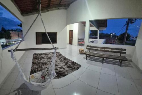 a room with a porch with a swing and a bench at Casa Duplex Gramuté - Praia Grande - ES in Fundão