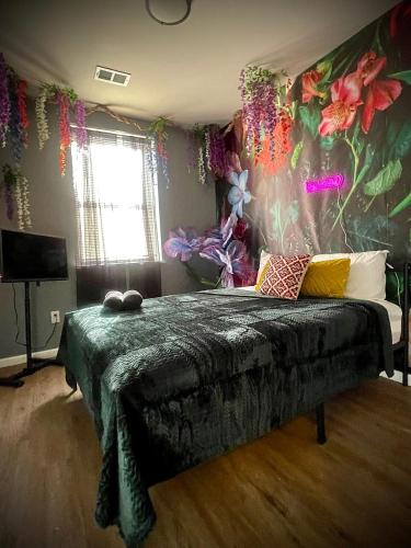 a bedroom with a bed with flowers on the wall at Garden Hideaway Minutes to Fishtown in Philadelphia