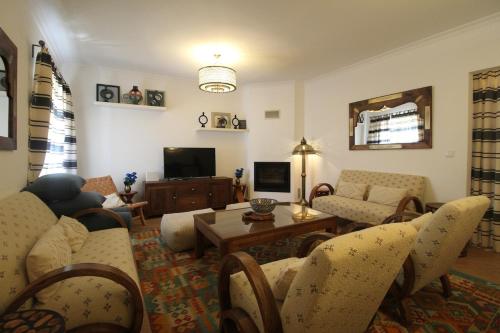 a living room with a couch and a table at Casa Almira Vista Mar in Vila Nova de Milfontes