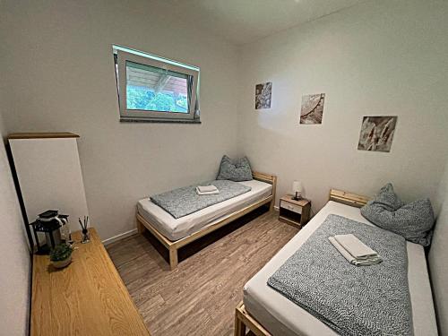 a room with two beds and a window at Vilstal Apartments in Reisbach