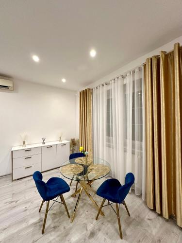 a dining room with a glass table and blue chairs at Luxury apartment in Bratislava in Trnávka