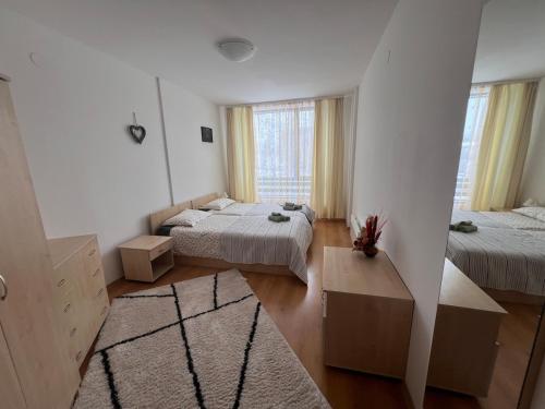 ein großes Zimmer mit zwei Betten und einem Fenster in der Unterkunft Bansko Aspen Relax & Chill in Bansko