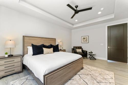a bedroom with a large bed and a ceiling fan at Desert Sands l Private Spa l Sleeps Twelve in Hurricane