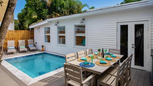 a patio with a table and chairs next to a pool at The Duke and The Queen by Last Key Realty in Key West