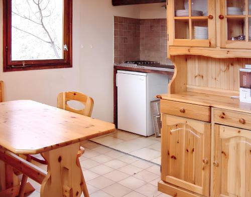 a kitchen with wooden cabinets and a wooden table at Bungalow confortable à Escaro avec piscine partagée in Escaro