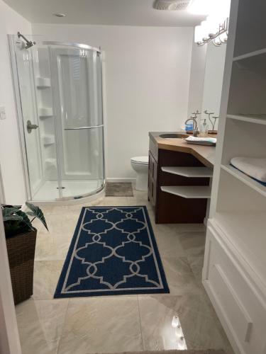 a bathroom with a shower and a blue rug at Welcome to Shibly's Retreat in Edmonton