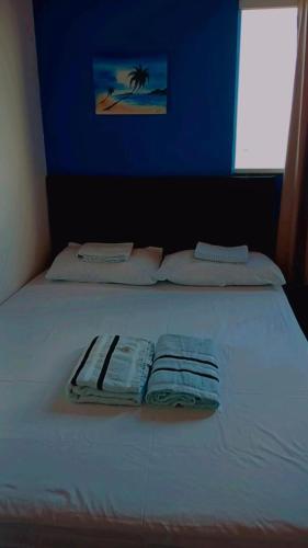a white bed with two folded towels on it at Chalé marlin azul in Icapuí