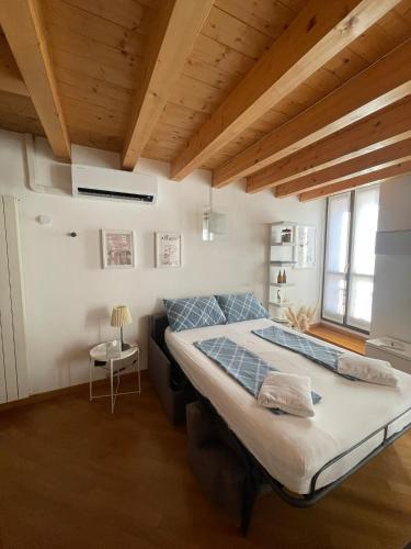 a bedroom with a large bed in a room with wooden ceilings at Riso e Latte Casa Vacanze in Pisogne