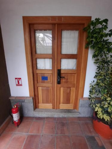 a wooden door in a room with a potted plant at Hostal Suite Le Fabrique in Cuenca