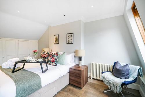 a bedroom with a bed with a table and a chair at Beautiful and spacious 2 bed, 2 bath apartment bordering Fulham and Chelsea - entire apartment with private entrance in London