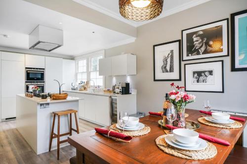 a kitchen and dining room with a wooden table at Beautiful and spacious 2 bed, 2 bath apartment bordering Fulham and Chelsea - entire apartment with private entrance in London
