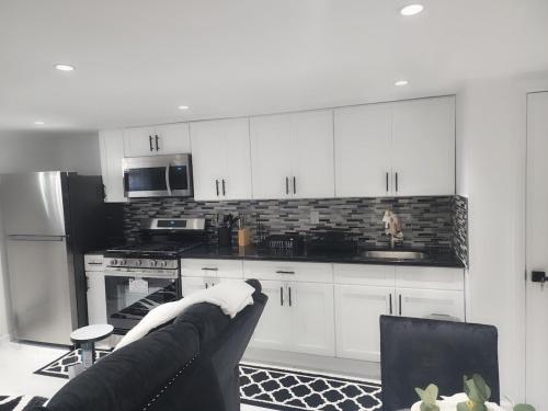 a kitchen with white cabinets and a couch in a room at Baldwin, NY 1 Bedroom Apartment Queen Size Bed in Baldwin