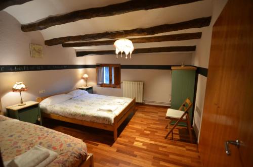 una camera da letto con due letti e un lampadario di Casa del Molí a Pontons