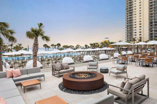 an outdoor patio with chairs and tables and a fire pit at Royale Palms Condominiums in Myrtle Beach