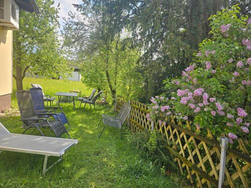 a yard with chairs and flowers and a wooden fence at Ferienwohnung Melissa in Unter Feuchten
