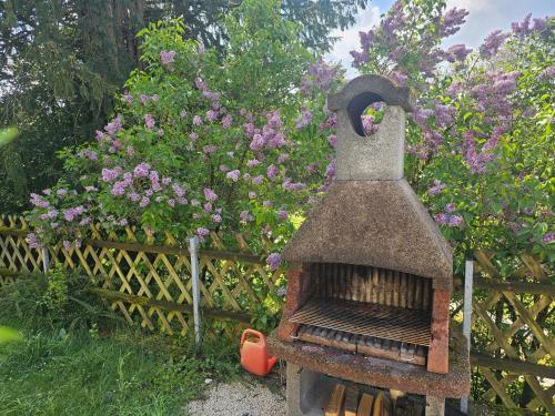 a bird feeder in front of a fence with flowers at Ferienwohnung Melissa in Unter Feuchten
