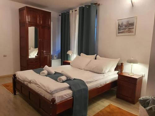 a bedroom with a large bed with a green curtain at Dvata Smurcha Central Apartments - Free Parking in Bansko