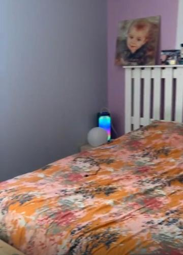 - une chambre avec un lit et une couverture fleurie dans l'établissement Villa Soleil et Sérénité, à Vénéjan