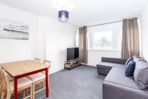 a living room with a couch and a table at Coastal Charm 1br Flat Near The Sea Street Parking in Hollington